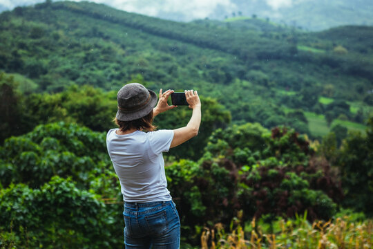 Asian female tourists take pictures of mountain landscapes after rain in northern Thailand.