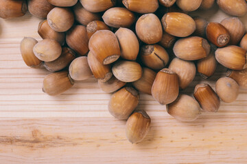 Pile of nuts. Whole nuts. Corylus avellana. Macro photo, close up, top view on wooden table.