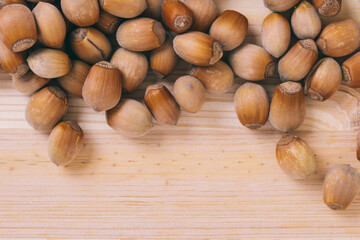 Pile of nuts. Whole nuts. Corylus avellana. Macro photo, close up, top view on wooden table.