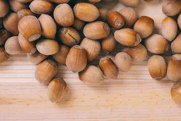 Pile of nuts. Whole nuts. Corylus avellana. Macro photo, close up, top view on wooden table.