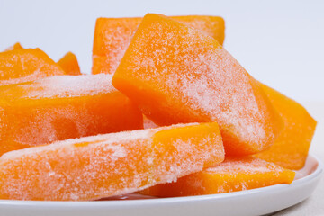 Frozen pieces of pumpkin on the plate.