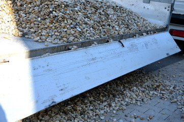 delivery of gray river pebbles like mulch to flower beds in the garden using a wheelbarow from the...