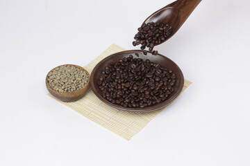coffee beans that have been roasted and dropped from a spoon, juxtaposed against fresh coffee beans, to show the different color of the coffee beans.