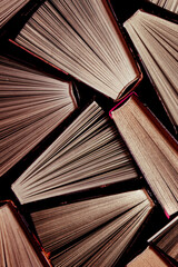 Naklejka premium Book background from multi-colored open books from the home library