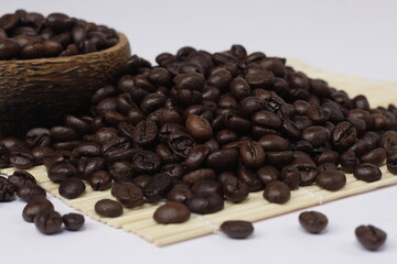 pile of roasted coffee beans, exotic black and emitting a distinctive aroma of coffee.