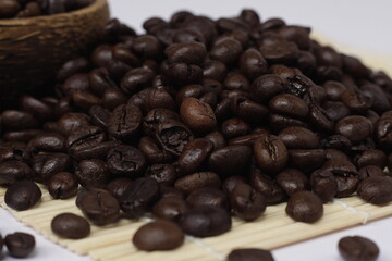 pile of roasted coffee beans, exotic black and emitting a distinctive aroma of coffee.