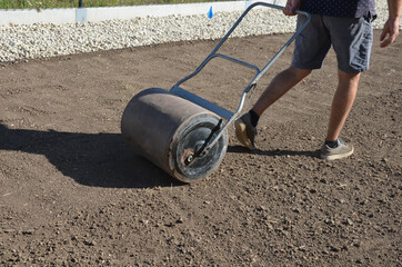 soil preparation before sowing the lawn with a soil cultivator. soil loosening, raking, sowing. the...
