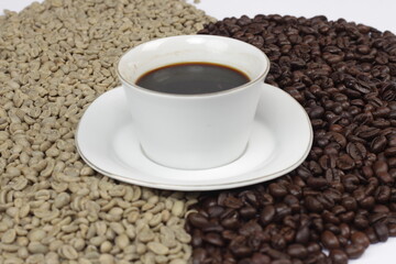 Black coffee is served in a glass cup, which is placed on top of the coffee beans. There are coffee beans that have been roasted and are still fresh beans.