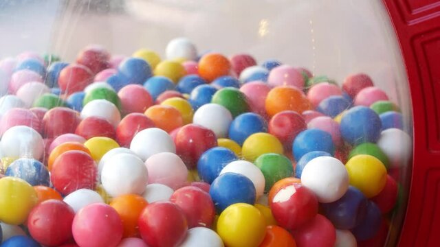 Colorful gumballs in classic vending machine, USA. Multi colored buble gums, coin operated retro dispenser. Chewing gum candies as symbol of childhood and summertime. Mixed sweets in vintage automate.