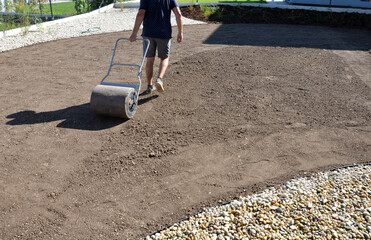 soil preparation before sowing the lawn with a soil cultivator. soil loosening, raking, sowing. the...