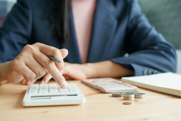  Hand of businesswoman doing calculating and account banknote on table