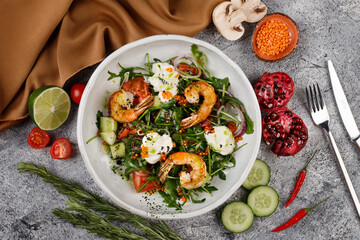 Salad with shrimp, arugula ,cucumber and onion on a white plate