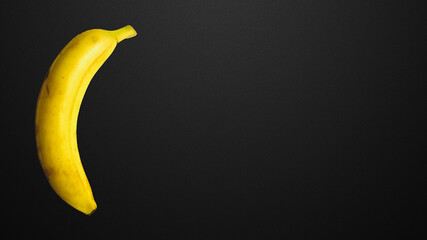 Yellow banana on a black background.