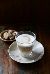 Glass of Latte Macchiato. Rustic wooden background. Close up.