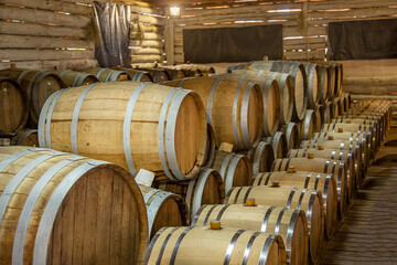 Wooden wine barrels are found at the winery. They are ready to pour or are already filled.