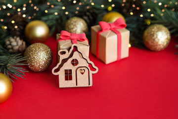 Christmas wooden toy house on red christmas background. Concept staying at home. Space for text.