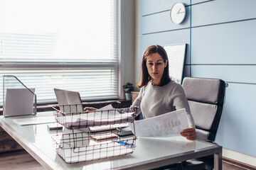 Woman sits at table and reads a document