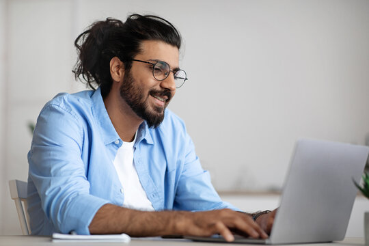 Busy Indian IT Manager Guy Working On Laptop At Workplace In Office