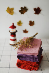 Stack of colourful linen towels or pile of textile napkins on kitchen table. Fall home decoration. Autumn cozy mood still life