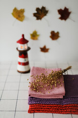 Stack of colourful linen towels or pile of textile napkins on kitchen table. Fall home decoration. Autumn cozy mood still life
