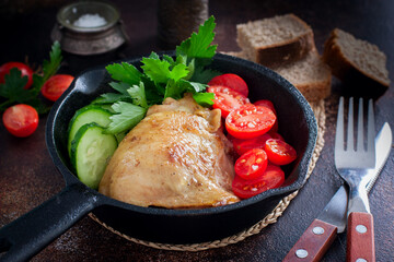 Fried chicken thighs in a portioned cast iron pan, selective focus