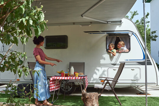 Two children staring out the window of a caravan at a delicious breakfast