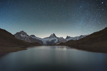 Incredible night view of Bachalpsee lake in Swiss Alps mountains. Snowy peaks of Wetterhorn,...