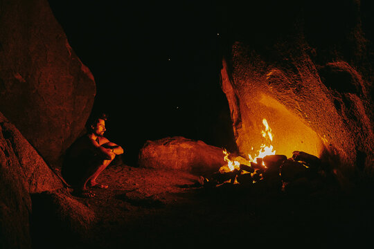 Young man in front of camp fire at night in northern California.