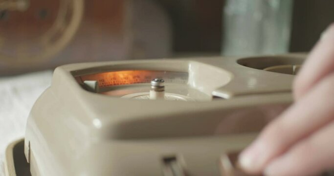 Man is  powering up a retro sound recorder.