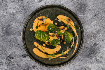 Cabbage rolls in a salad leaf with herbs and sauce