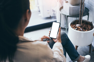 cell phone mockup blank white screen.woman hand holding texting using mobile on desk at coffee shop.background empty space for advertise.work people contact marketing business,technology