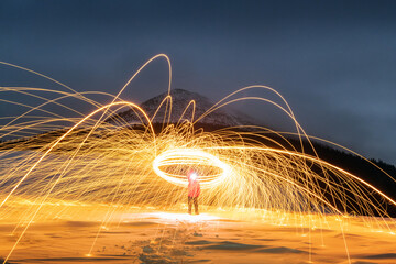 Fire show with lot of sparks in night winter mountains. Landscape photography