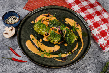 Cabbage rolls in a salad leaf with herbs and sauce