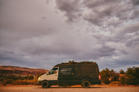 Camper van off side of dirt road during golden sunset in Moab, Utah.