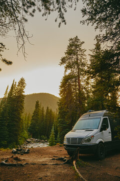 Camper van by riverbed during golden hour sunset near Aspen, Colorado.