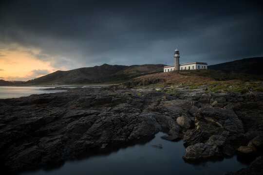 Scenic view of Faro de Punta Larino lighthouse on coastline during sunset