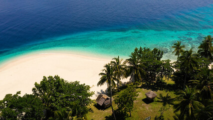 Tropical island with a beach and palm trees. Beautiful lagoon and white sandy beach, aerial view. Mahaba Island, Philippines. advertising concept