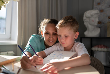 Focused mother and son sketching in planner