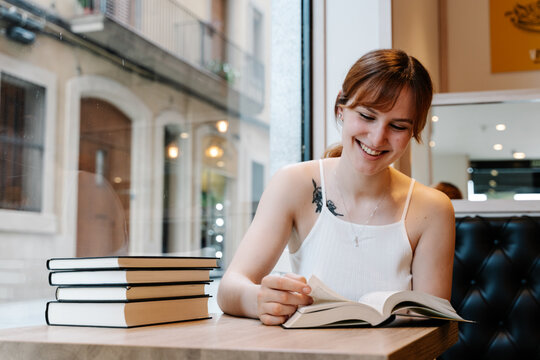 Young woman reading books in a coffee shop