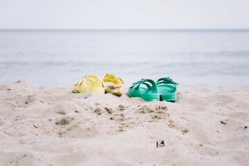 two pairs of sandals on a sandy beach in summer
