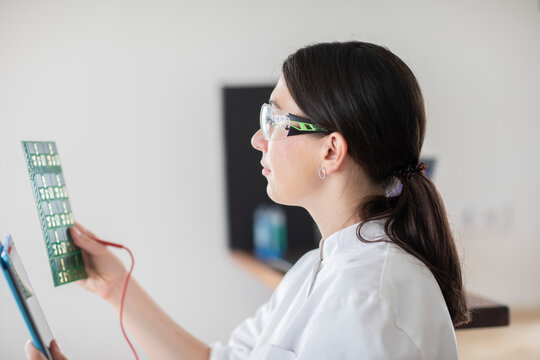 scientist female with lab glasses, tablet and samplein a lab