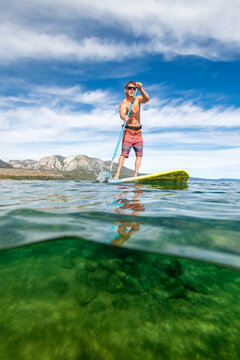 A man stand up paddle boarding on Lake Tahoe, CA