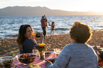 A family enjoys a beach picnic on the shoreline of Lake Tahoe, NV