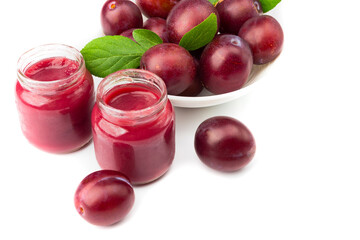 Violet fresh ripe plums and a glass with a puree from plums