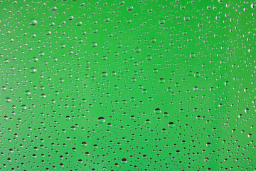 Water drops texture on glass on light green background. Abstract background.