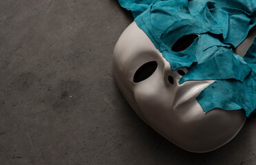 White theater mask on a black background covered with leather flaps. Psychic symbol of overlapping...