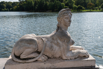 Fototapeta na wymiar Statue of the Sphinx on the pier pond. Tsaritsyno Park