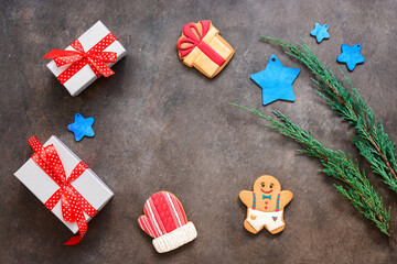Christmas composition. Round frame made of gingerbread, blue stars, gift box and green coniferous branches on a dark rustic background. Top view, flat lay, copy space.