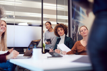 Businesswoman Arriving Late For Presentation By Colleague In Modern Office