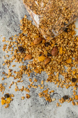 oatmeal or granola with almonds and hazelnut for nutritious breakfast on white marble background